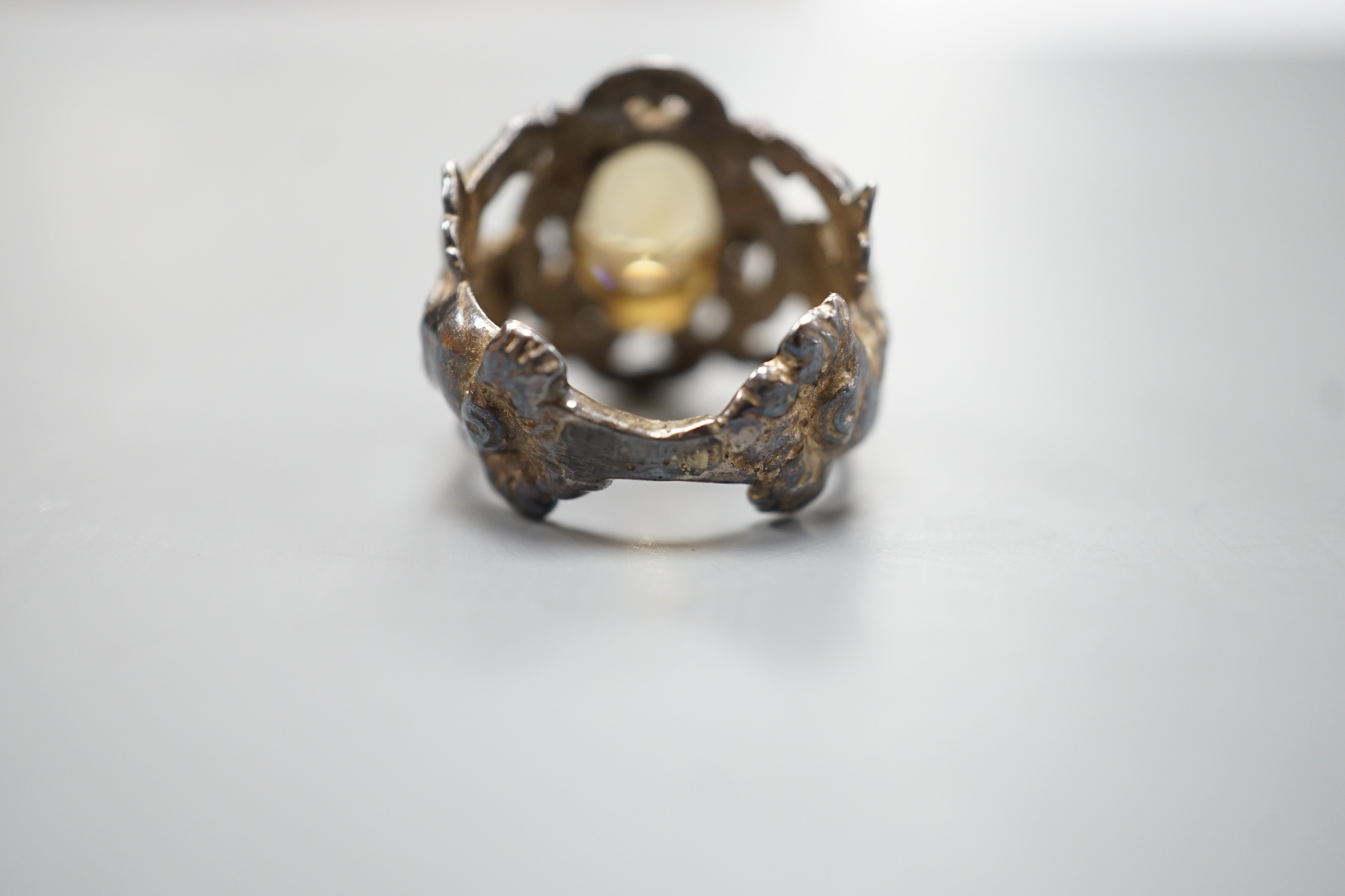 A 1960's silver and oval cut citrine set ring, the shank modelled and twin cupids, size O, gross weight 9.2 grams.